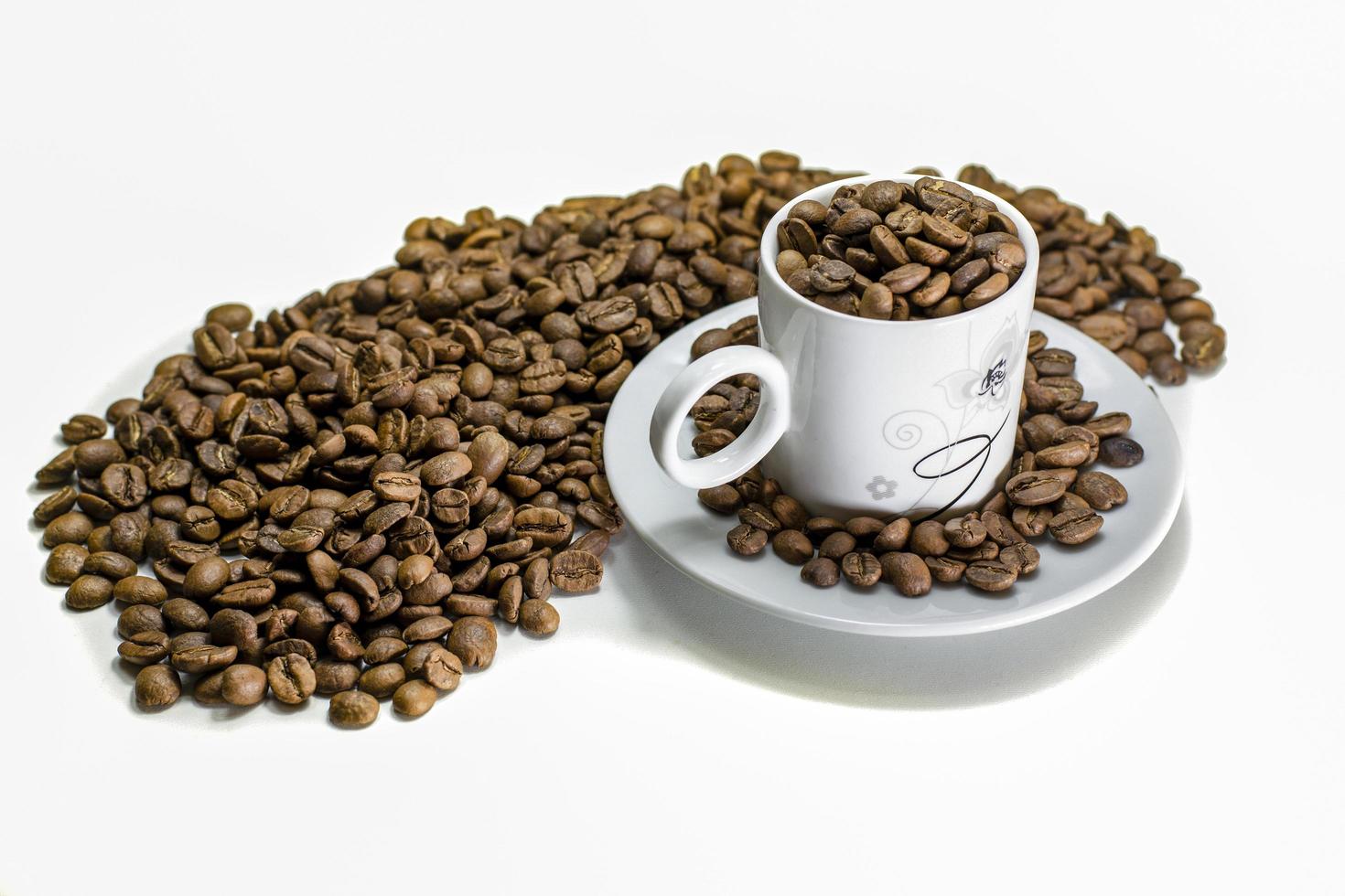 chicchi di caffè in tazza e piano del tavolo sul tavolo bianco foto