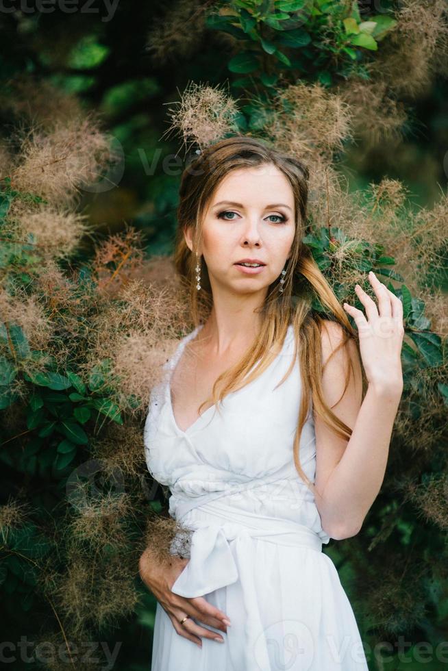 ragazza felice in un abito lungo turchese in un parco verde foto