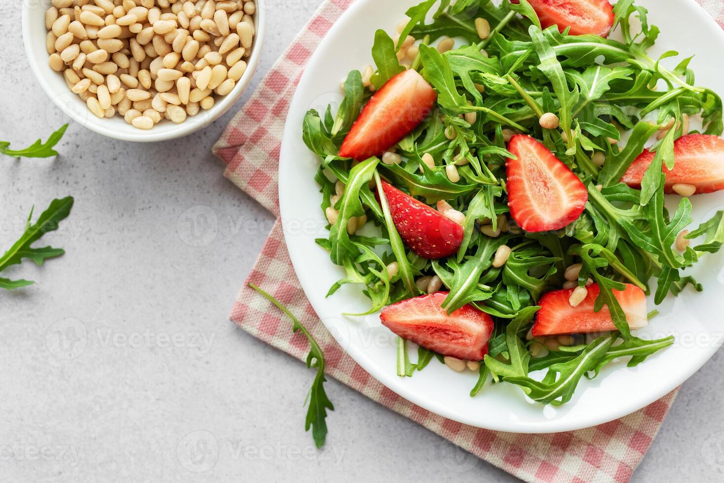 fresco fragola rucola insalata con pino noccioline servito su un' luminosa giorno foto