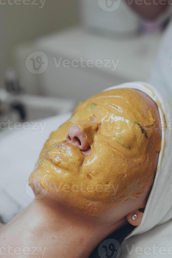 un' ragazza a un' cosmetologo fa cosmetico procedure. alginato maschera foto