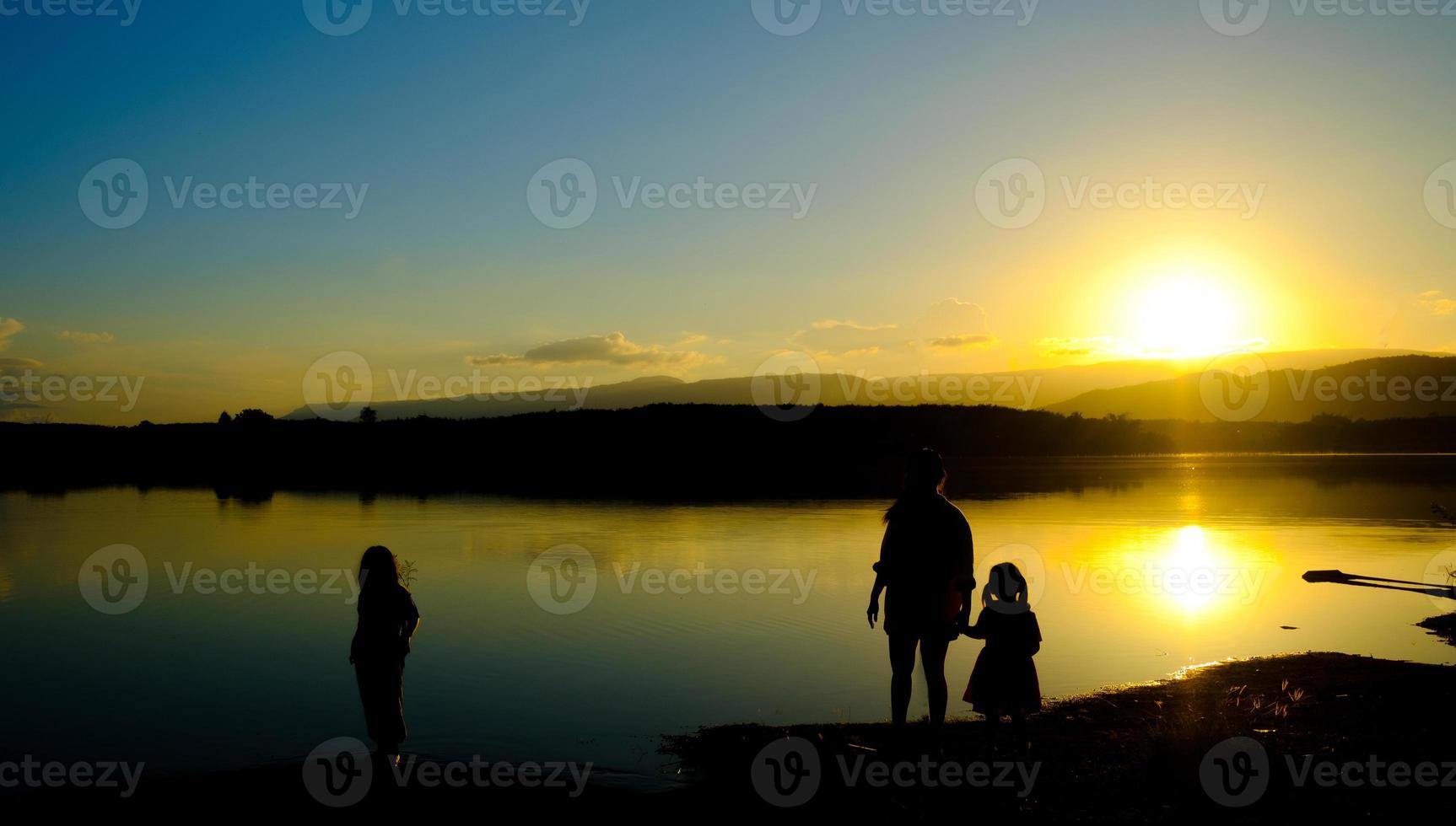 sagome di madre e figlio stanno sul lago all'ora del tramonto, serbatoio amphoe wang saphung loei thailand foto