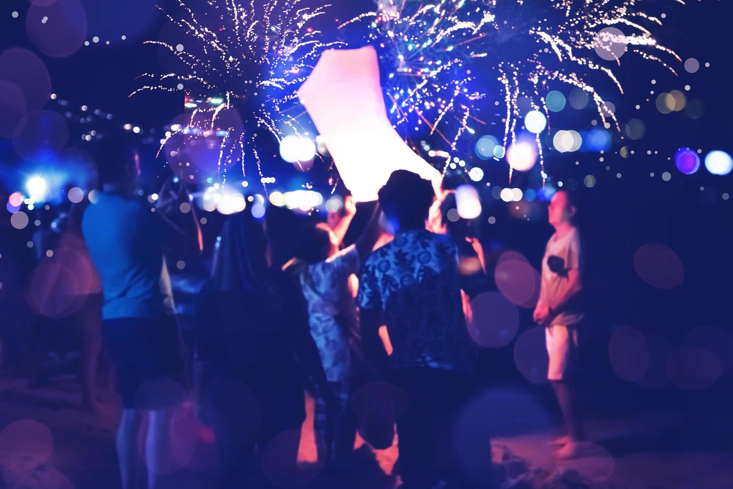 la gente festeggia il nuovo anno. sfocatura del cerchio di fuochi d'artificio. colorato in festa. spiaggia thailandese foto