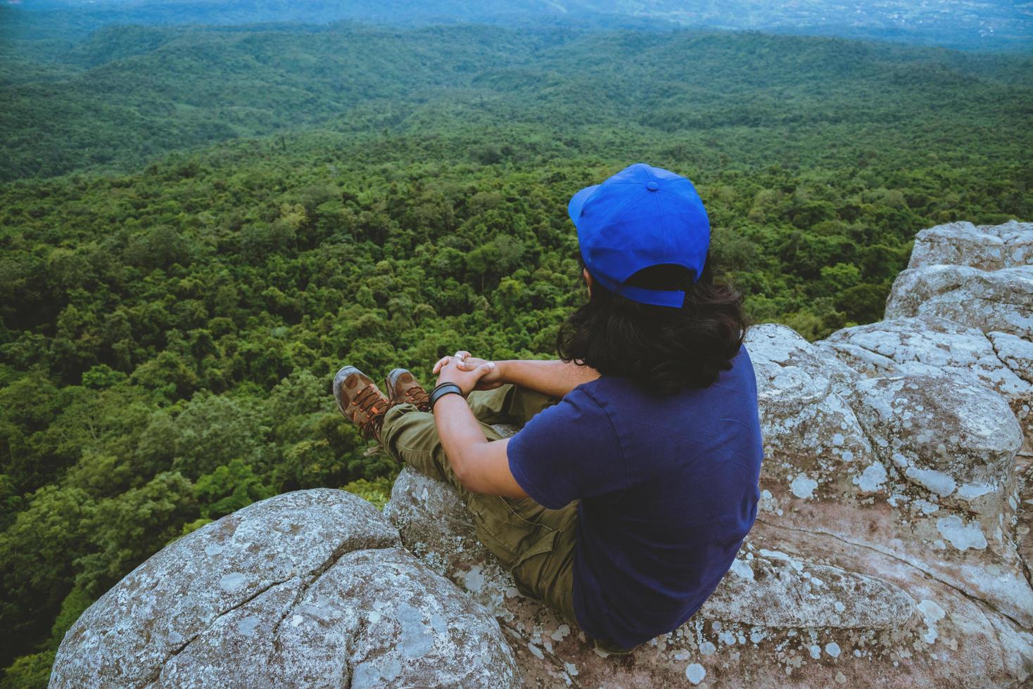 gli asiatici dell'uomo viaggiano rilassati durante le vacanze. visualizzare la natura di montagna sulle scogliere. foto