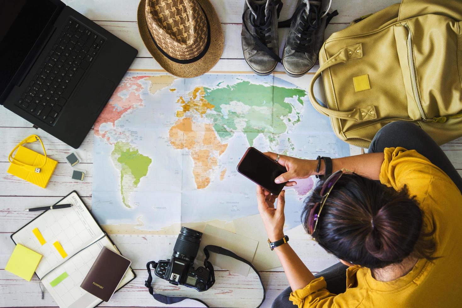 concetto di pianificazione dei viaggi di vacanza con la mappa. vista dall'alto dell'attrezzatura per i viaggiatori. sfondo del concetto di viaggio, giovane donna asiatica. vacanza di viaggio, estate. foto