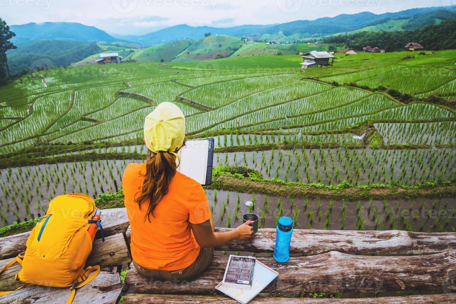 natura di viaggio donna asiatica. viaggiare rilassati. in piedi libro di lettura sul balcone di casa. in estate. foto