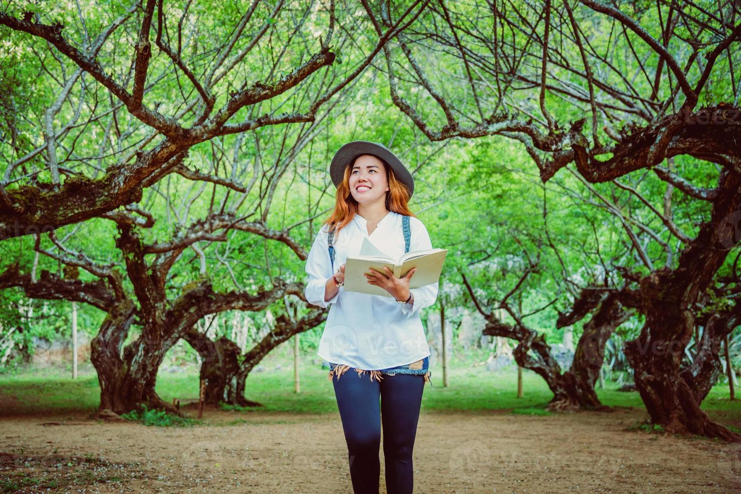 natura di viaggio donna asiatica. viaggiare rilassati. libro di lettura sul nel parco. in estate. foto