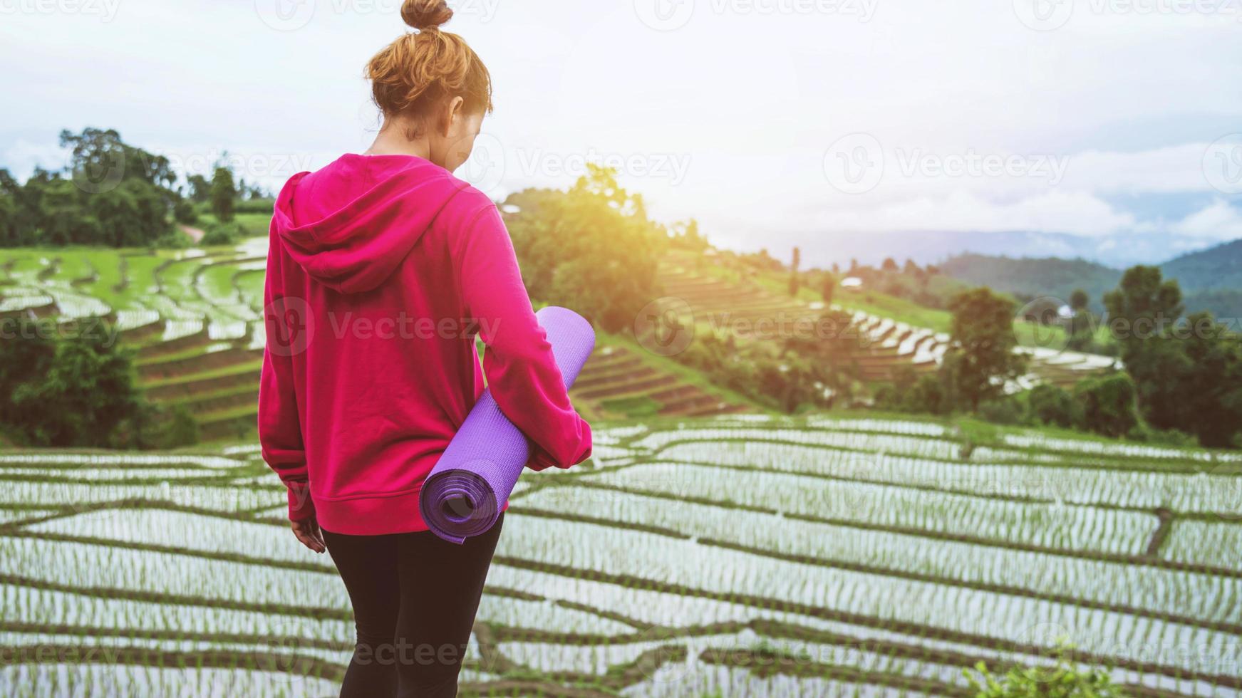 donna asiatica rilassarsi in vacanza. gioca se lo yoga. sul balcone paesaggio campo naturale foto