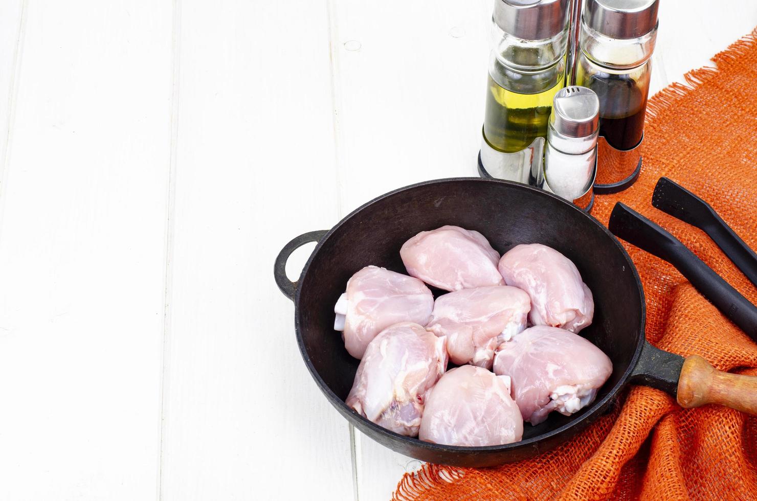 pezzi crudi di coscia di pollo in padella per cucinare. foto in studio.