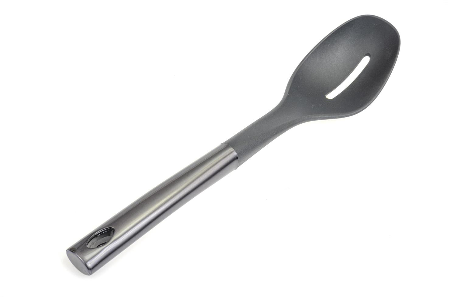 cucchiaio culinario in plastica nera, spatola forata, gadget da cucina. utensile da cucina. isolato foto