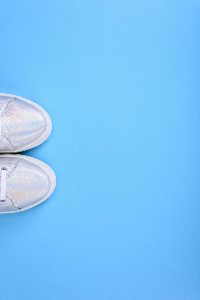 scarpe da ginnastica argento su sfondo blu con posto per il testo foto