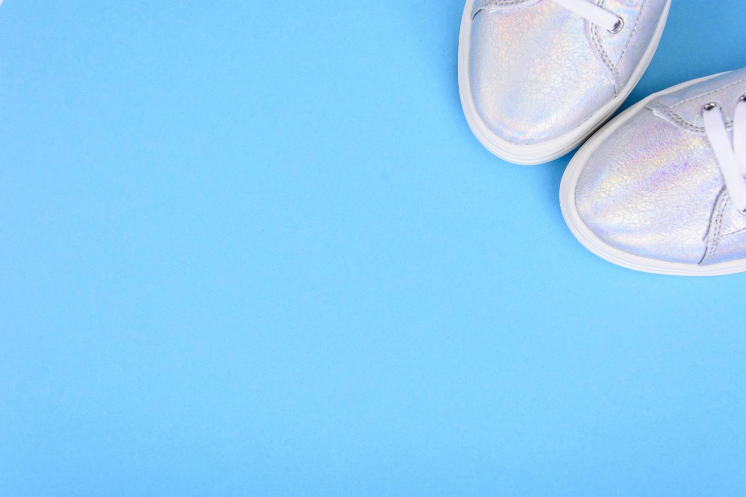 scarpe da ginnastica argento su sfondo blu con posto per il testo foto