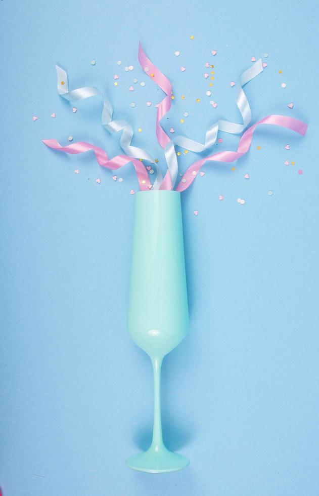 sfondo astratto con bicchiere di champagne blu, nastri e coriandoli. può essere utilizzato per San Valentino, invito di compleanno. sfondo rosa amore e sentimento per poster, banner, post, card foto