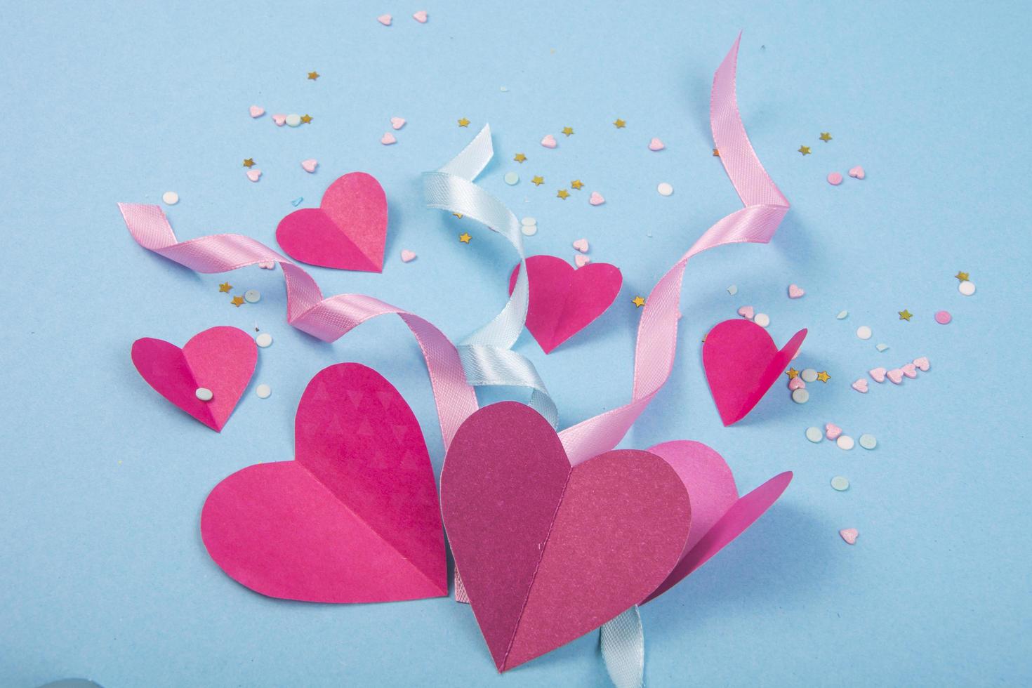 sfondo astratto con cuori di carta, nastri per san valentino. sfondo blu di amore e sentimento per poster, banner, post, card foto