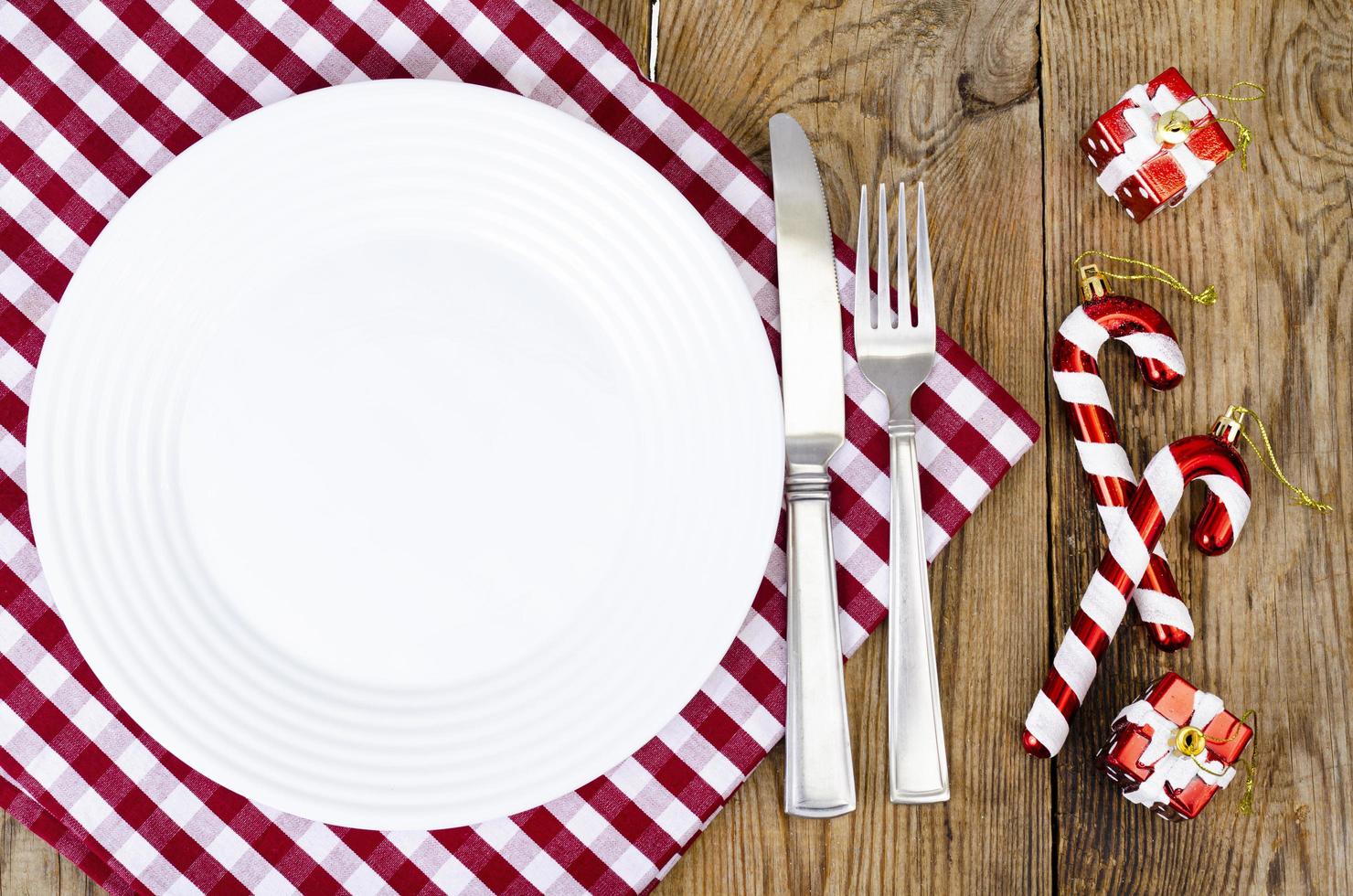 concetto di natale e capodanno. piatto bianco, tovaglia rossa. foto in studio