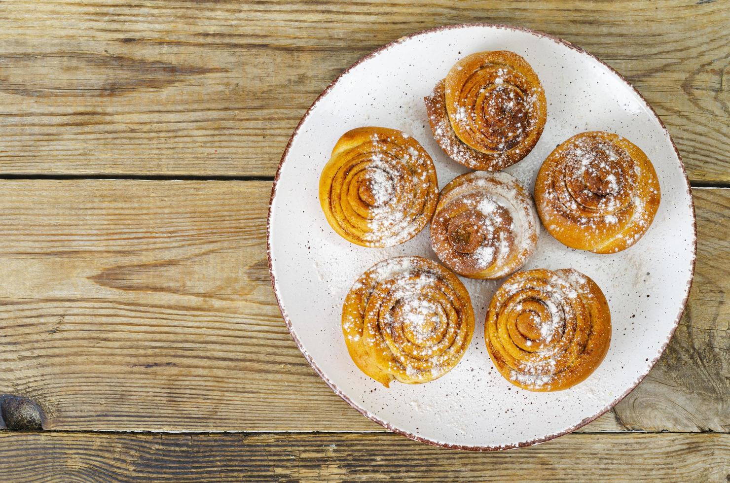 piatto di panini alla cannella fatti in casa sul tavolo di legno. foto in studio