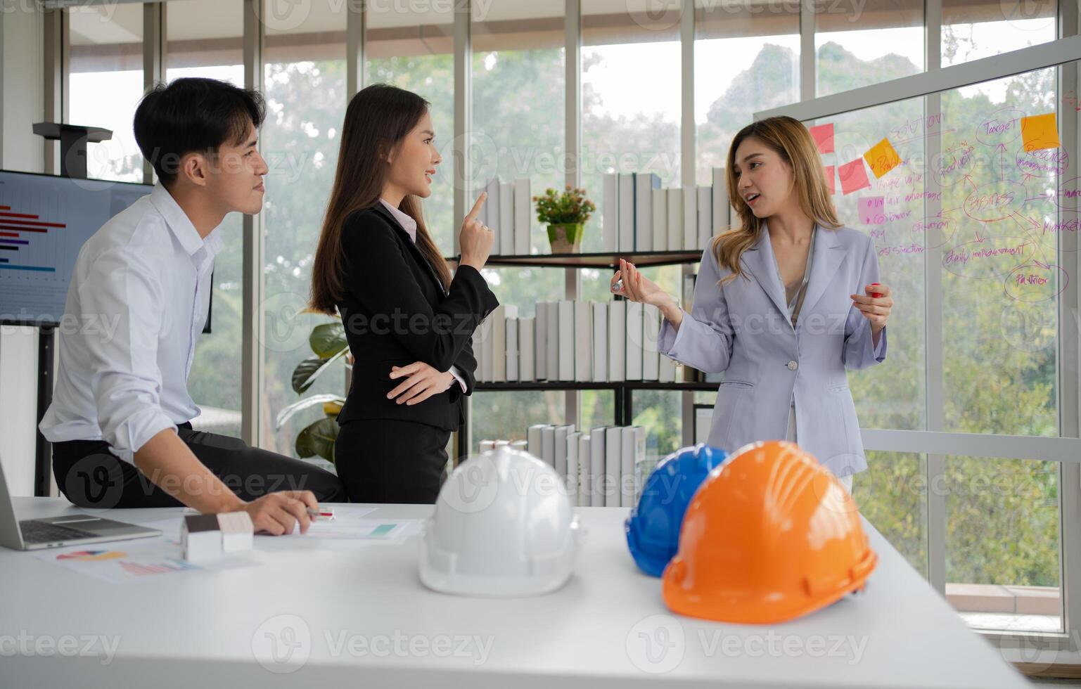 gruppo di asiatico uomini d'affari e ingegneri Lavorando e di brainstorming nel ufficio. competente costruzione squadra avendo discussione durante incontro. squadra architetto guardare a progetti nel un' edificio luogo foto