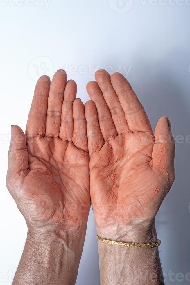 mani di un indiano donna con rosso holi polvere applicato su mano isolato su bianca sfondo. foto