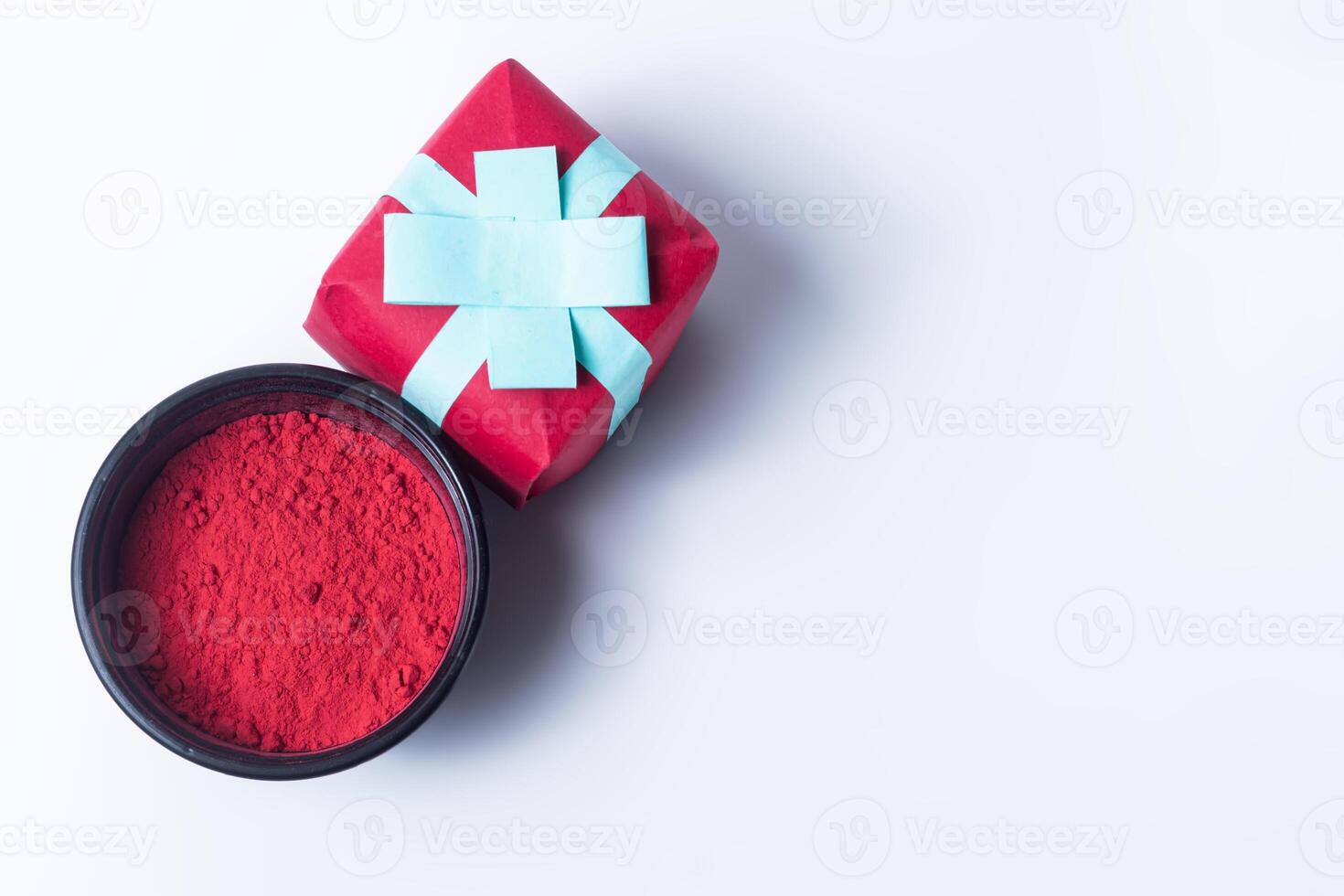regalo scatola con rosso holi polvere su bianca sfondo. foto