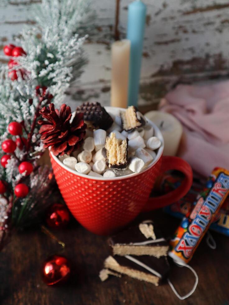 tazza di caldo cacao con marshmallows e cannella su un' tavolo con Natale decorazione foto