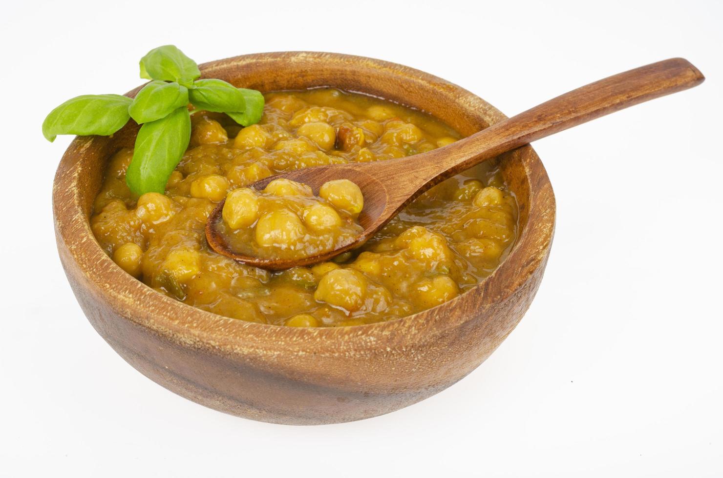 ceci con salsa al curry in ciotola di legno. foto in studio