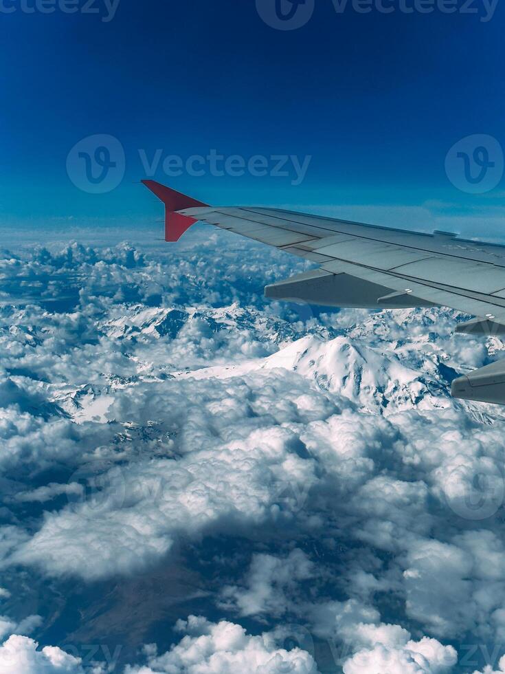 Visualizza di un' ripido roccioso snow-capped montagna gamma a partire dal un aereo finestra foto