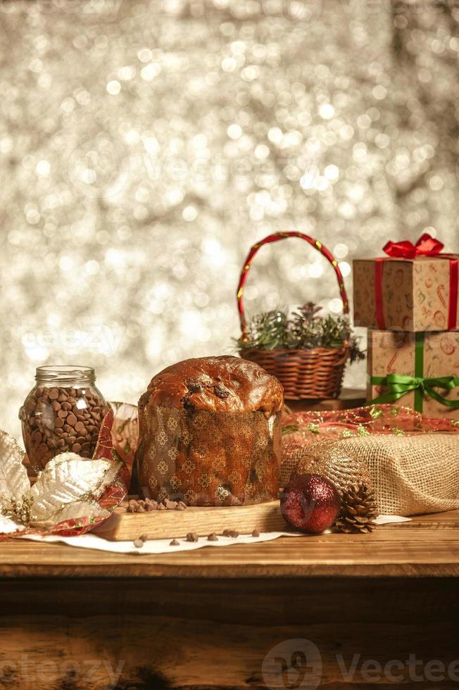 panettone al cioccolato su tavola di legno con addobbi natalizi foto