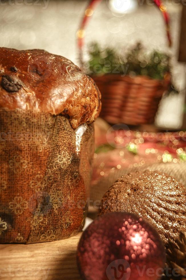 panettone al cioccolato su tavola di legno con addobbi natalizi foto