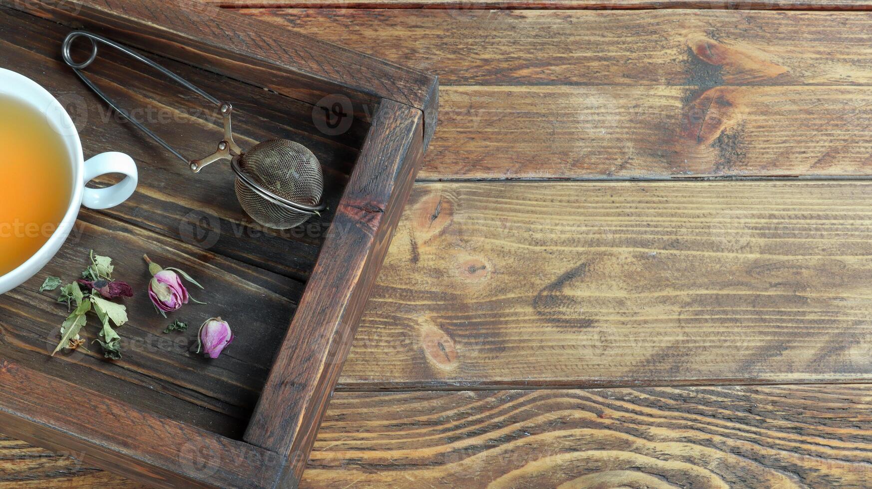 un' buio di legno vassoio con un' tazza di erbaceo tè foto