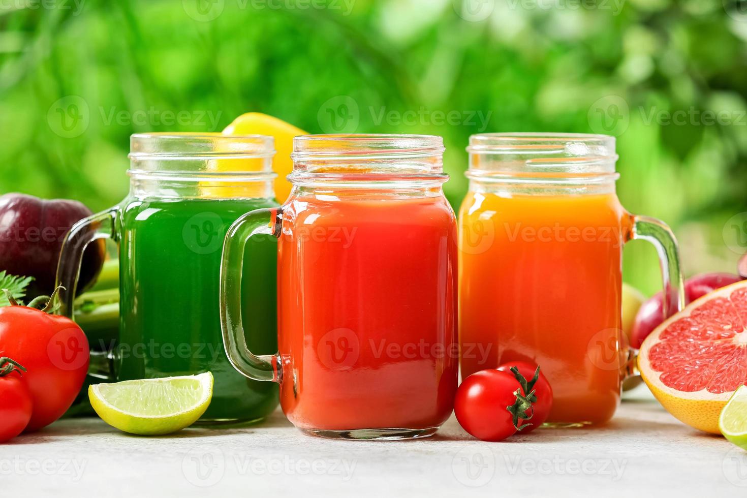 barattoli di muratore con succo sano, frutta e verdura sul tavolo all'aperto, primo piano foto