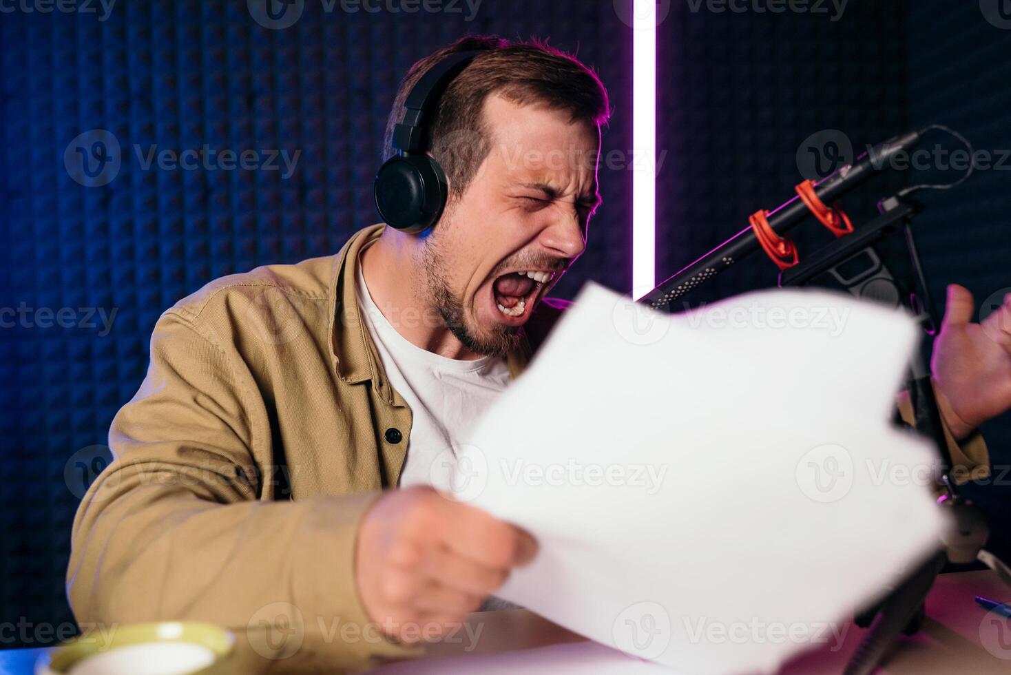 espressive e emotivo Radio ospite con cuffie lettura notizia a partire dal carta in studio microfono a Radio stazione con neon illuminazione foto