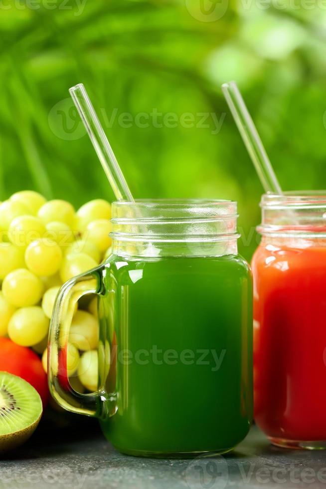 barattoli di muratore con succo sano, frutta e verdura sul tavolo all'aperto, primo piano foto