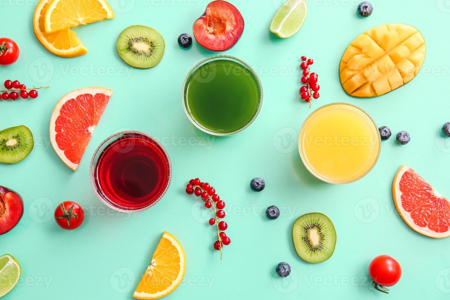 bicchieri con succo sano, frutta e verdura su sfondo colorato foto