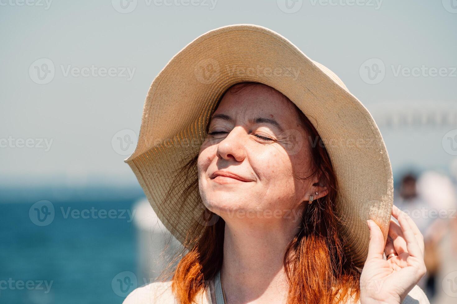 un' dai capelli rossi donna gode un' sereno momento, occhi Chiuso, con il sole su sua viso foto