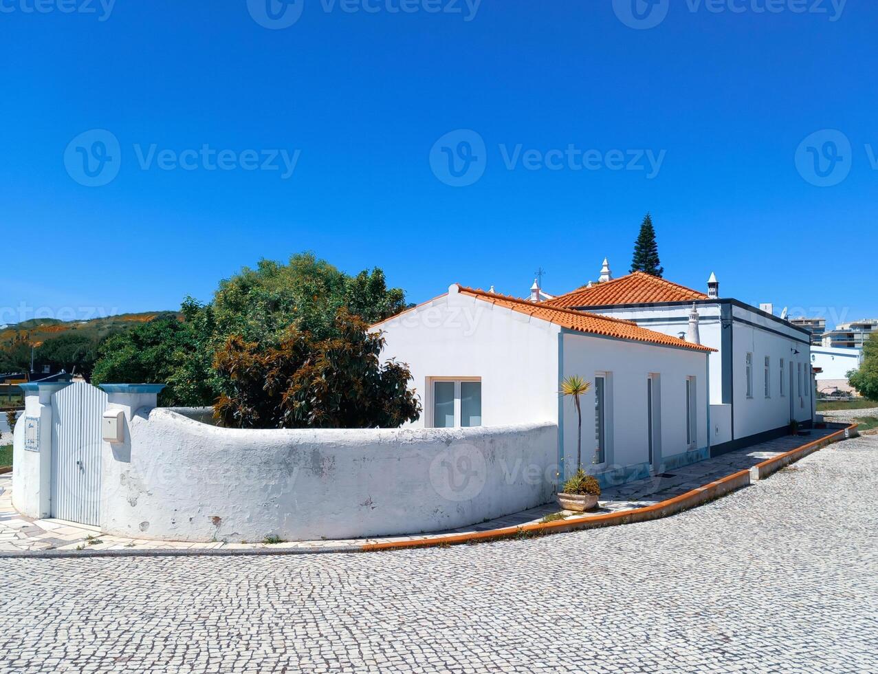 un' bianca Casa con un' rosso piastrelle tetto collocato nel un' mediterraneo regione. foto