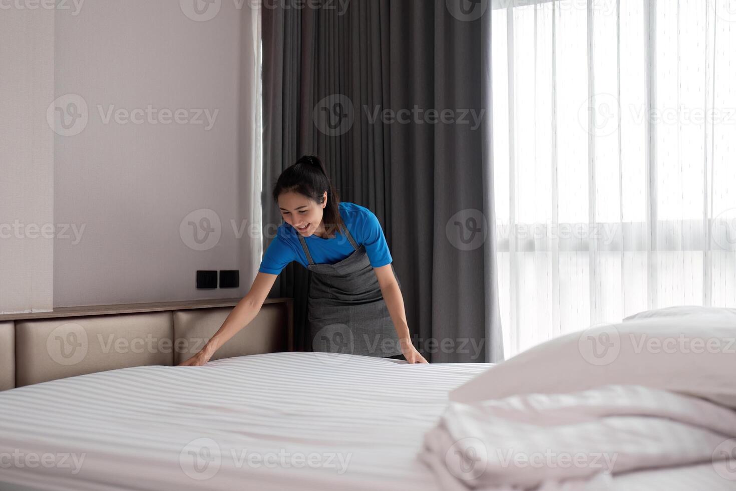 un' donna asiatico personale pulizia servizio, attrezzo e secchio per opera. un' giovane femmina addetto alle pulizie con prodotti per pulito un' Camera da letto foto