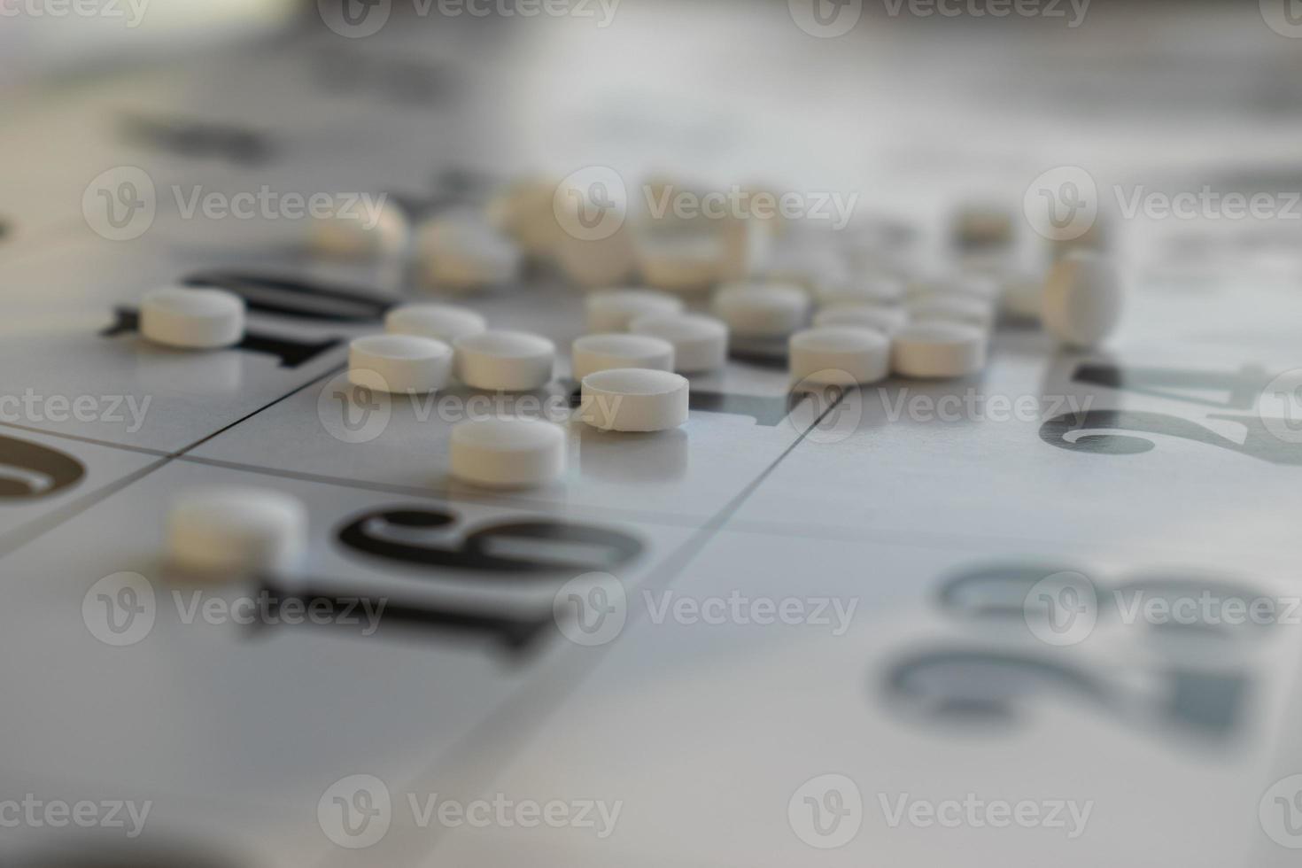 foto concettuale con le pillole. pillole bianche su uno sfondo di calendario.