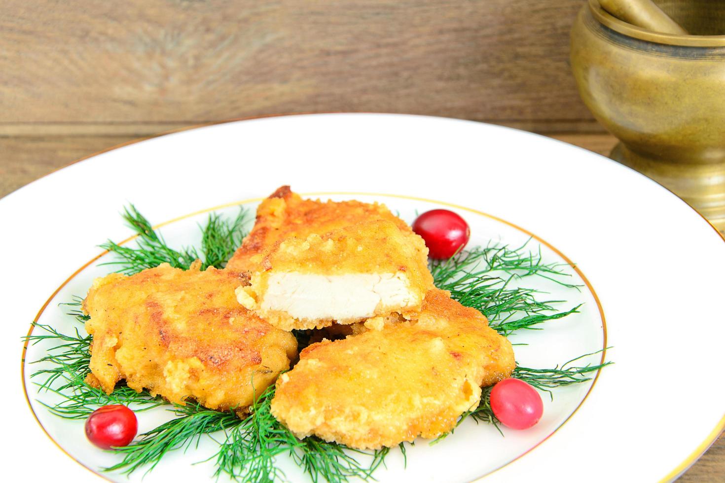 filetto di pollo impanato con erbe e mirtilli rossi. foto