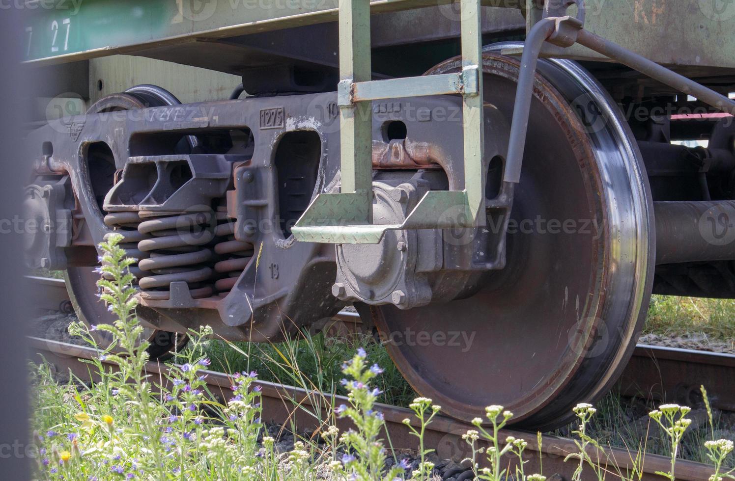 il sottocarro del carrello con ruote e molle. treno passeggeri, treno merci. le ruote ferroviarie industriali si chiudono. foto