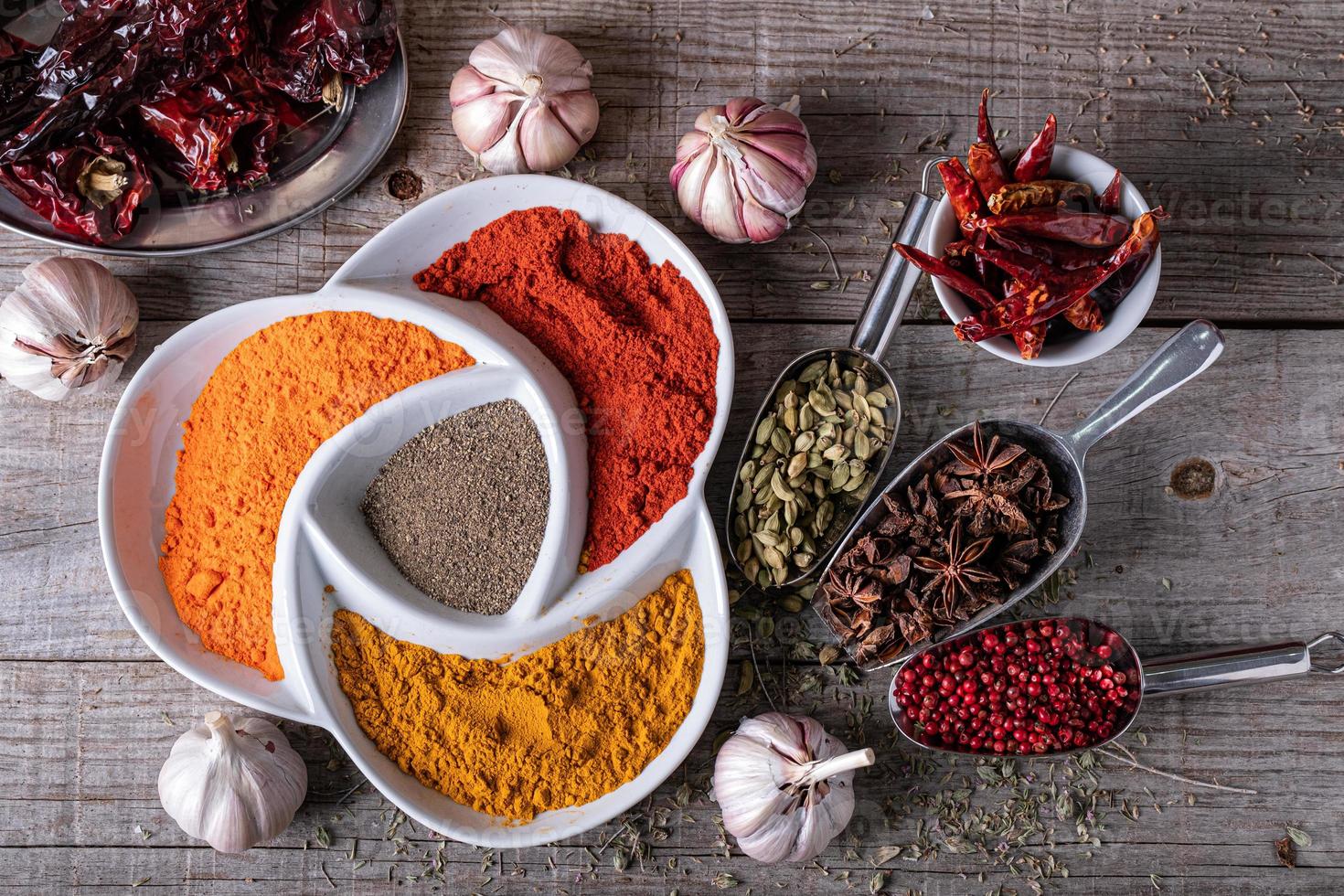 varietà di spezie ed erbe dai colori esotici indiani, sul tavolo della cucina foto