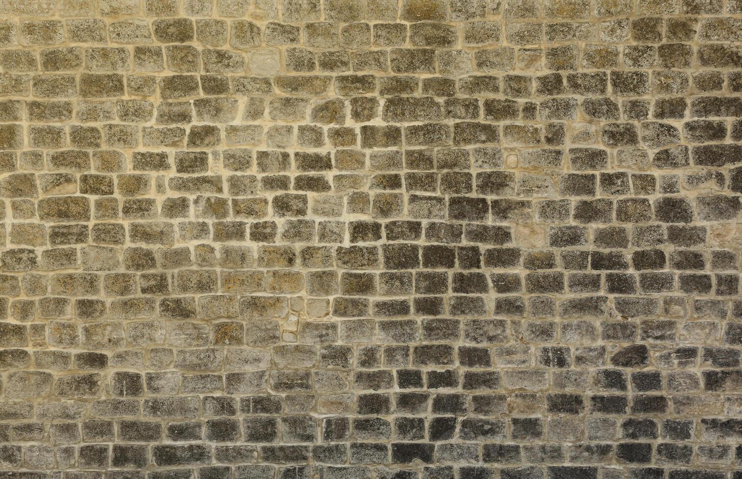 molto vecchio mattone pietra parete di castello o fortezza di 18 ° secolo. pieno telaio parete con obsoleto sporco e Cracked mattoni foto