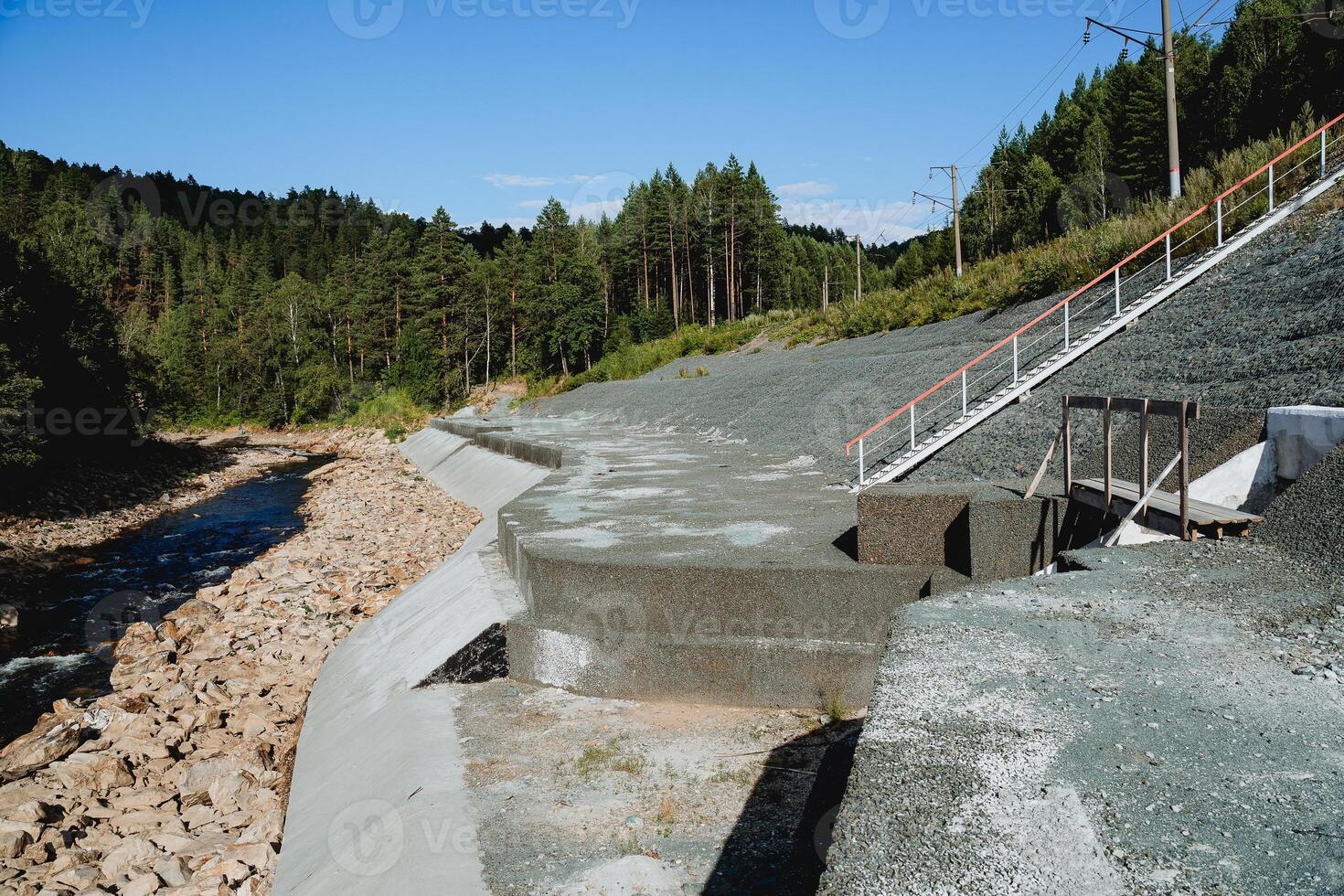 rafforzamento il costa di un' montagna fiume, proteggere il ferrovia a partire dal crollo, un' montagna fiume nel il estate, un' drenaggio nel il montagne, un' diga fatto di calcestruzzo. foto