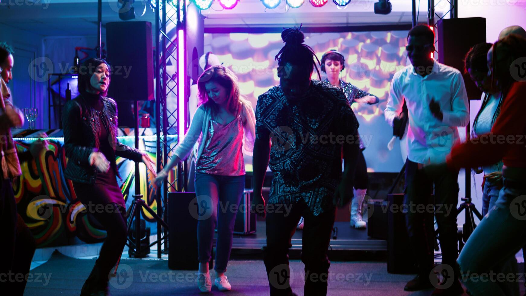 contento persone salto a danza festa, avendo divertimento a sociale raccolta nel discoteca. giovane impaurito amici mostrando danza si sposta su musica a club, colorato faretti. palmare sparo. foto