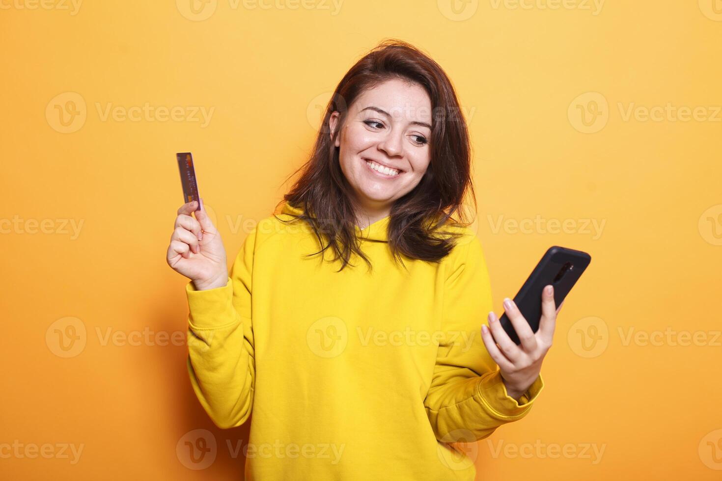 caucasico donna utilizzando un' smartphone per rendere un in linea Acquista mentre Tenere sua credito carta. positivo donna pagare per sua acquisti con un' mobile dispositivo e Internet bancario. foto