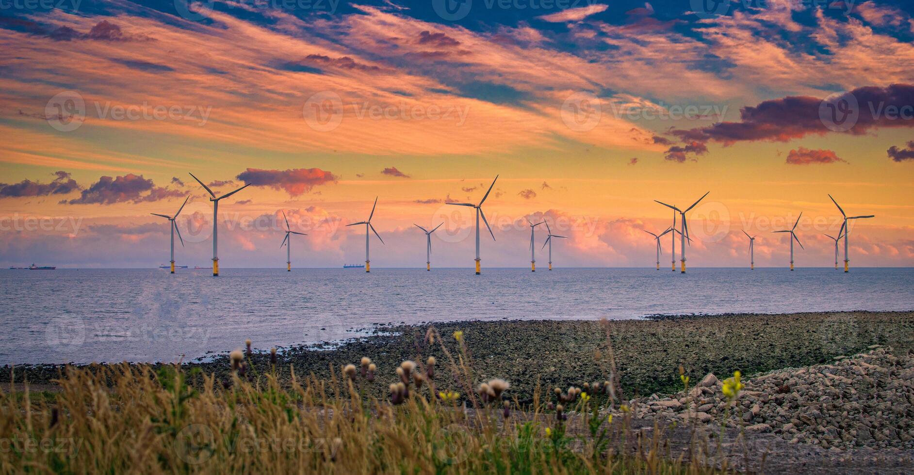 al largo vento turbina nel un' Parco eolico sotto costruzione via il Inghilterra costa a tramonto foto