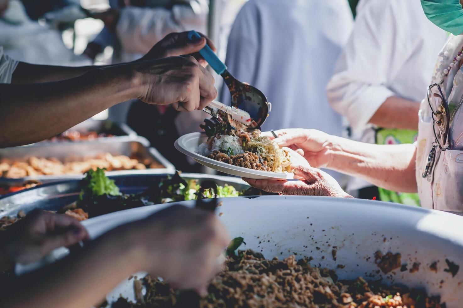 volontari offrire gratuito cibo per il povero. il concetto di cibo condivisione. foto