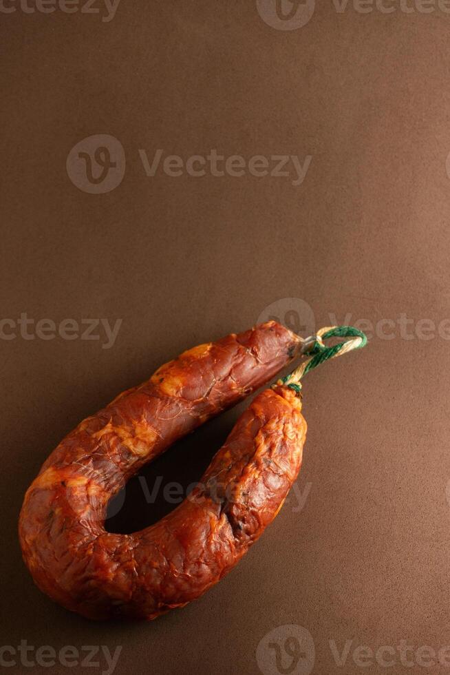 un' avvicinamento di un' tradizionale alentejo salsiccia, o linguistica, arrotolato su un' di legno tavola. suo Marrone rossastro colore e grossolano struttura riflettere il sapori di portoghese cucina. foto