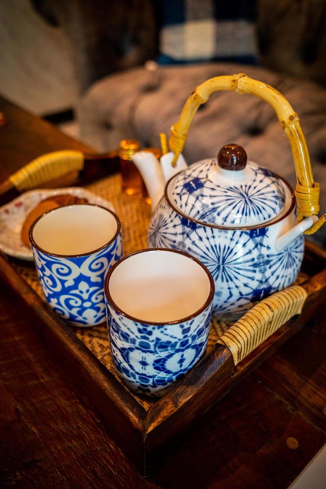 messa a fuoco ravvicinata sulla tazza in ceramica a strisce blu e bianca con set di bollitore. foto