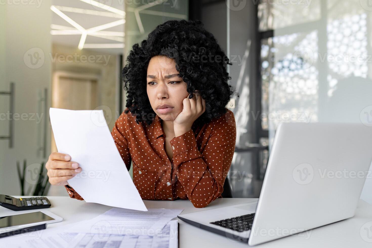 irritato e insoddisfatto donna a posto di lavoro, donna d'affari capo controllo documenti, conti e contratti, finanziario donna avuto cattivo risultati nel finanziario rapporti, Lavorando dentro ufficio con il computer portatile. foto