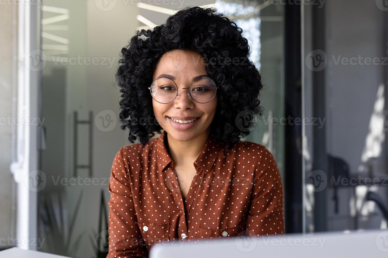 avvicinamento foto di giovane bellissimo attività commerciale donna con Riccio capelli e bicchieri ispanico donna.