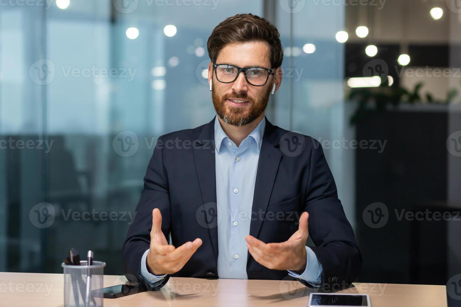 webcam Visualizza, maturo uomo d'affari ufficio parlando con colleghi remoto in linea, uomo guardare a telecamera e sorridente, riuscito investitore a opera nel attività commerciale completo da uomo, esecutivo nel bicchieri e barba. foto